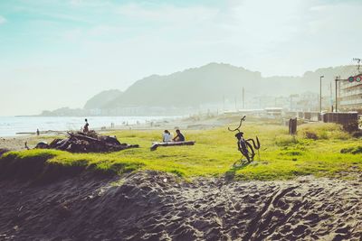 People riding bicycles on land against sky