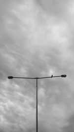 Low angle view of street light against cloudy sky