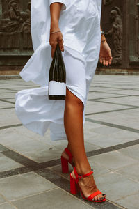 Low section of woman walking on footpath