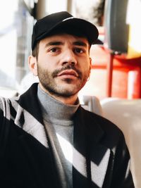 Portrait of young man wearing cap at home