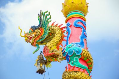 Low angle view of statue of dragon against sky