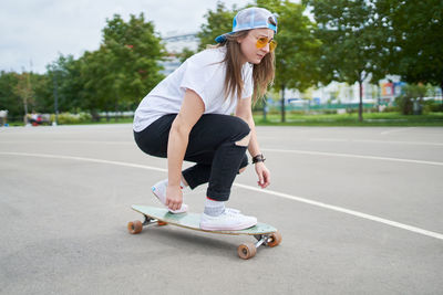 Beautiful woman skating on skateboard outdoors