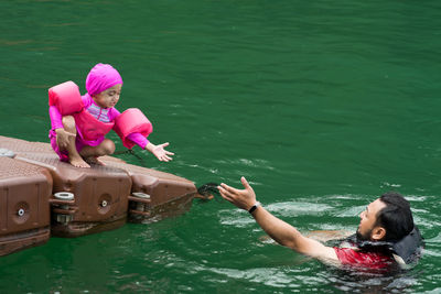 Rear view of women and woman in boat on lake