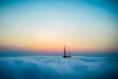 Sailboat sailing on sea against sky during sunset