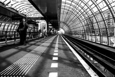 Rear view of man standing on railroad station platform