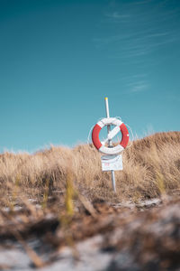 Lifebuoy on field against clear sky