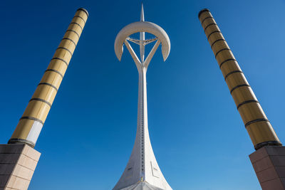 Low angle view of crane against clear blue sky