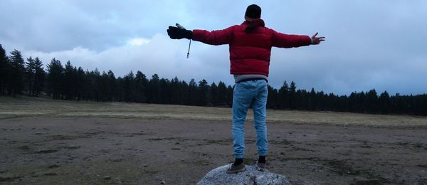 Full length of man standing on field against sky