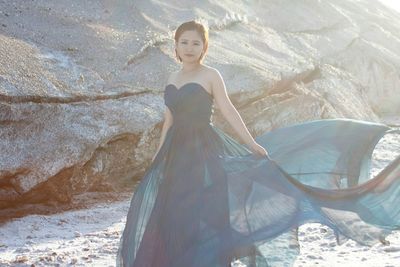 Portrait of young woman standing on sand