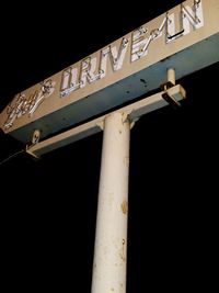 Low angle view of information sign against sky at night