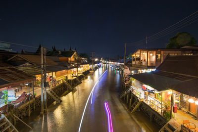 Illuminated bridge over canal in city at night