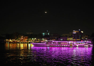 Illuminated buildings against sky at night