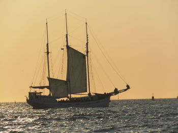 Sailboat sailing on sea against clear sky