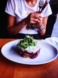 Midsection of woman holding ice cream in plate