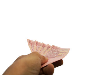 Close-up of hand holding umbrella against white background