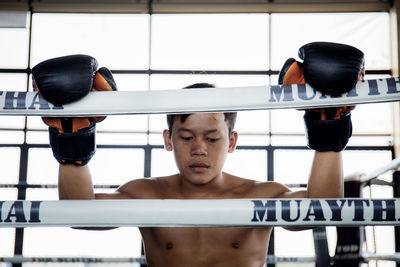 Boxer is holding a meditation rope on the thai boxing ring.