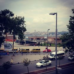 Cars on street by city against sky