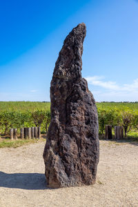 View of rock formation on field against sky