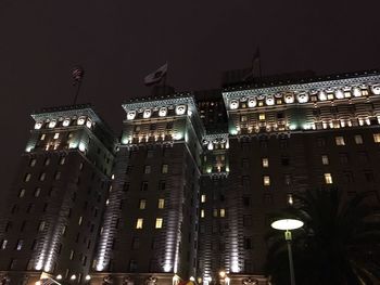 Low angle view of city lit up at night