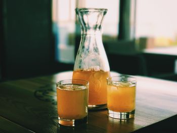 Close-up of juice in glass and container on table