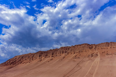 View of desert against cloudy sky