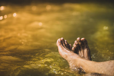 Low section of man relaxing in water