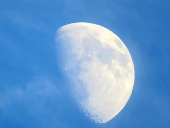 Low angle view of half moon against blue sky