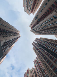 Low angle view of buildings against cloudy sky