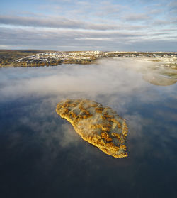 Small island in sea near coastal city