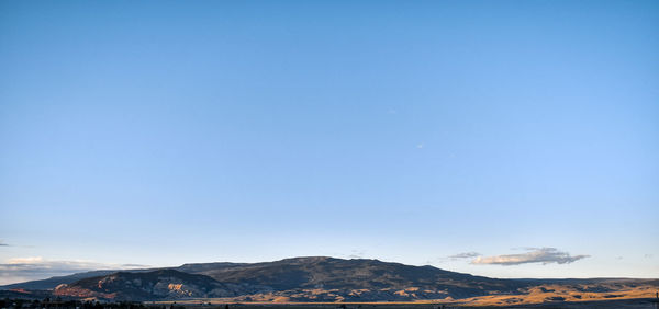 Scenic view of snowcapped mountains against clear blue sky