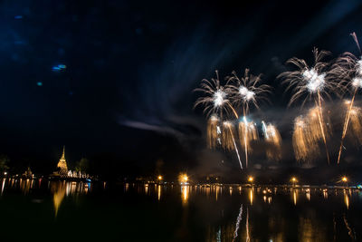 Firework display over river at night