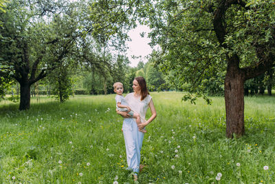 Young woman mom and son play in nature, spend time together and have fun