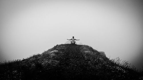 Man standing on cross against clear sky