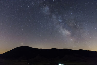 Scenic view of silhouette mountain against sky at night