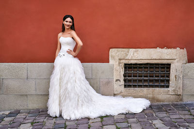 Portrait of woman standing against wall