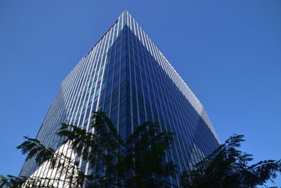 Low angle view of modern building against blue sky