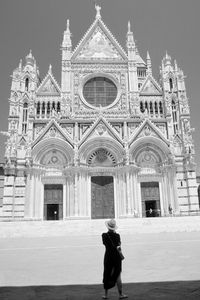 Rear view of man standing in front of historic building