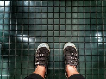 Low section of woman standing on tiled floor