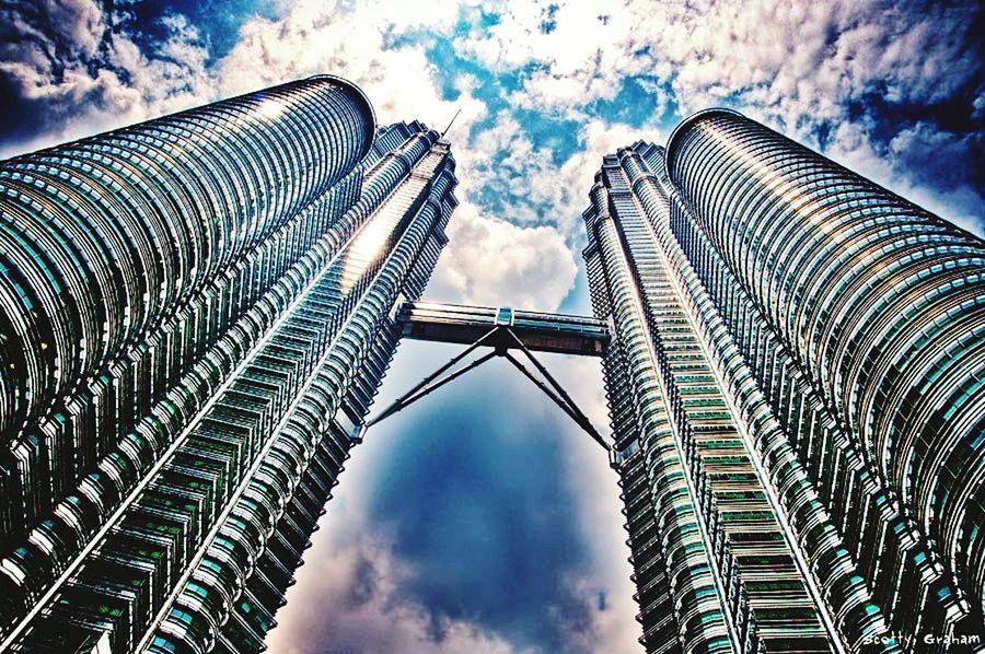 low angle view, sky, modern, built structure, architecture, skyscraper, tall - high, cloud - sky, building exterior, tower, office building, city, cloudy, cloud, famous place, capital cities, travel destinations, blue, day, tall