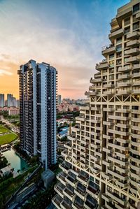 Modern buildings in city against sky during sunset