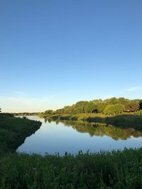 Scenic view of lake against clear blue sky