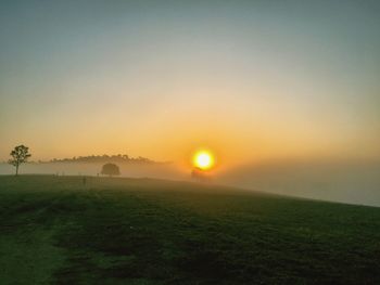 Scenic view of field against sky during sunset