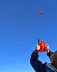 Low angle view of kite flying against clear blue sky