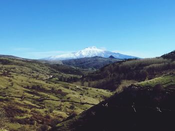 Scenic view of mountains against clear blue sky