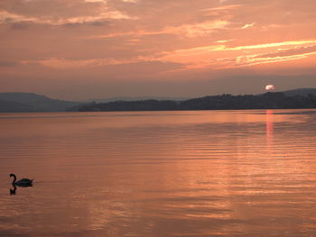 Scenic view of lake against orange sky