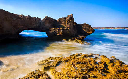 Scenic view of rocks in sea against sky