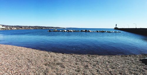 View of calm beach against clear sky