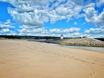 Scenic view of beach by sea against sky