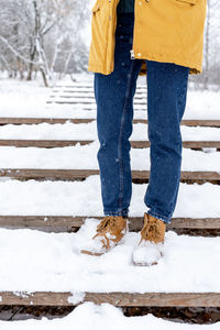 Low section of woman standing on snow
