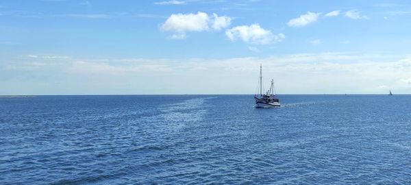 Sailboat sailing on sea against sky